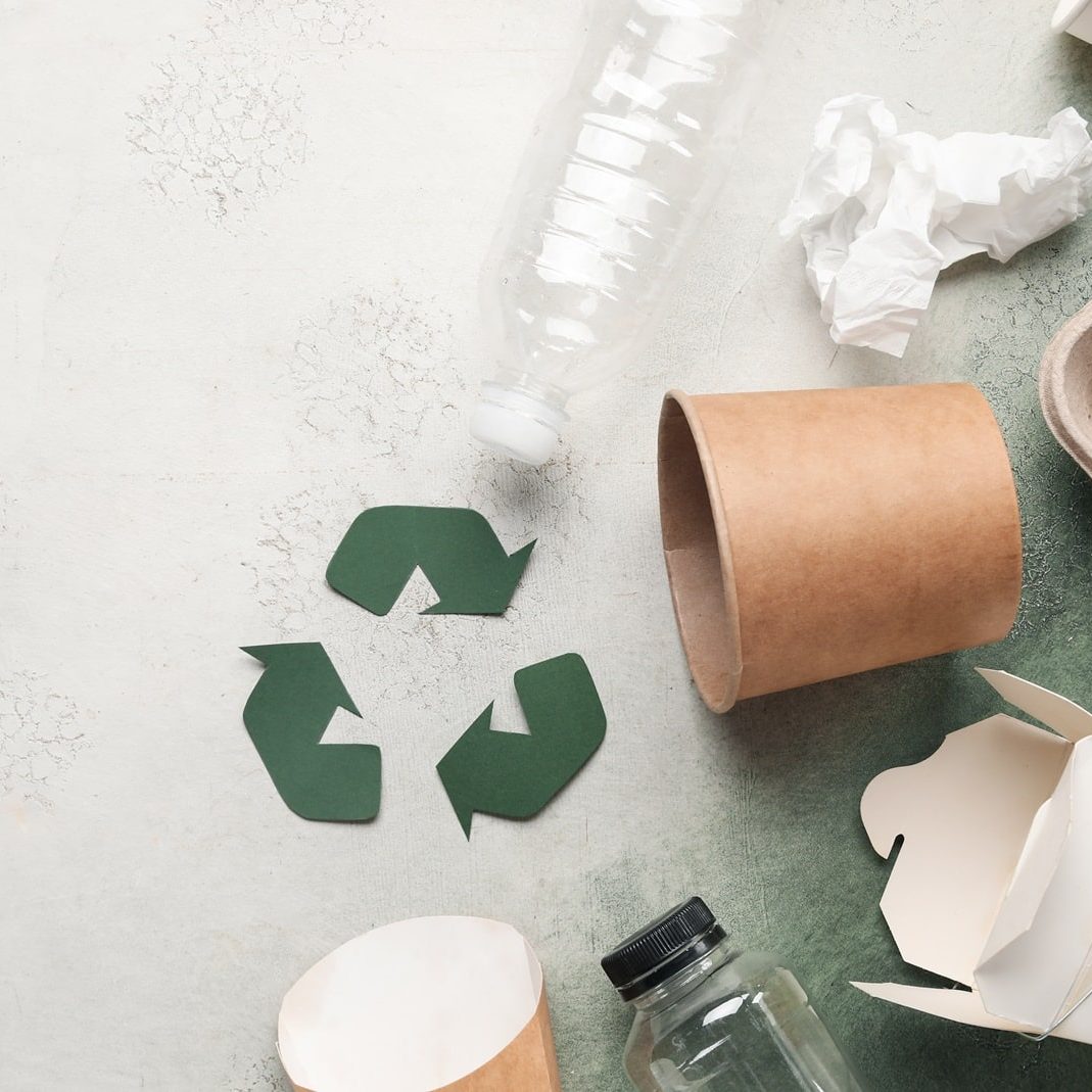 Recycling sign with garbage on grunge background